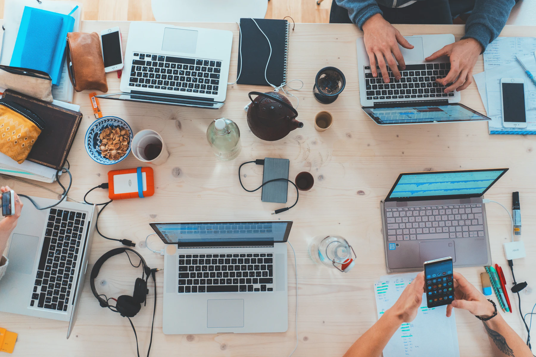 Equipo colaborando alrededor de una mesa de trabajo tecnológico